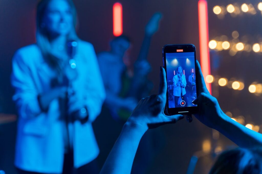 A vibrant live performance captured through a smartphone at a concert.